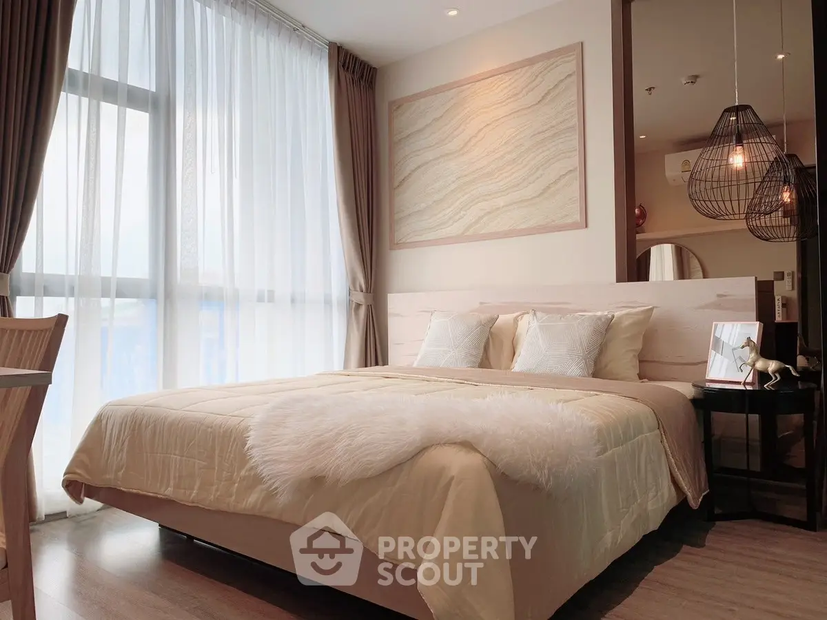 Luxurious bedroom with elegant decor and large window offering natural light.