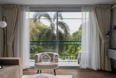 Modern living room with large windows and lush garden view, featuring elegant furniture and natural light.