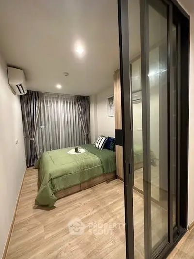 Modern bedroom with sliding glass doors and stylish decor in a cozy apartment.