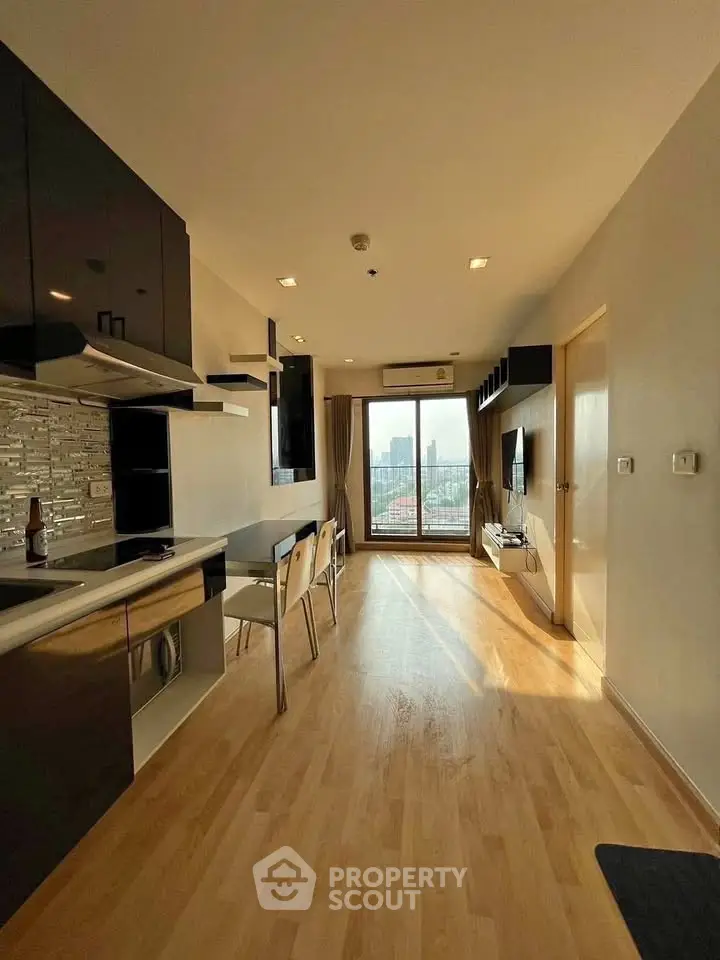 Modern apartment interior with open kitchen and city view, featuring sleek design and ample natural light.