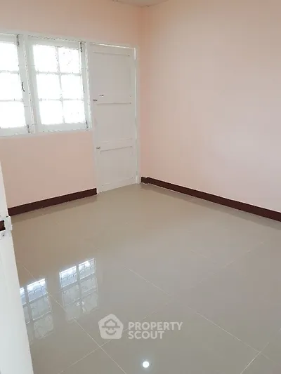 Bright empty room with tiled floor and large window, perfect for customization.