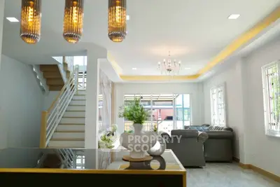 Spacious modern living room with elegant chandelier and stylish staircase in a bright open layout.