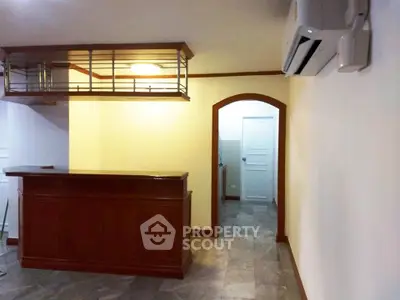 Charming interior with elegant wooden bar and modern air conditioning unit, perfect for entertaining guests.