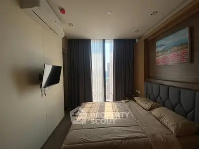 Modern bedroom with large window and wall-mounted TV in a stylish apartment.