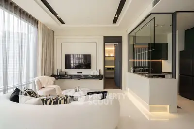 Luxurious modern living room with open kitchen, elegant decor, and natural light