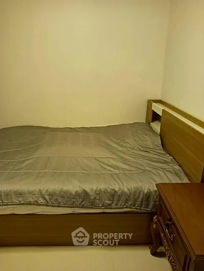 Cozy bedroom with wooden bed and nightstand, perfect for restful nights.