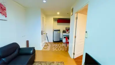 Modern apartment interior with cozy living room and compact kitchen area, featuring sleek furniture and bright lighting.