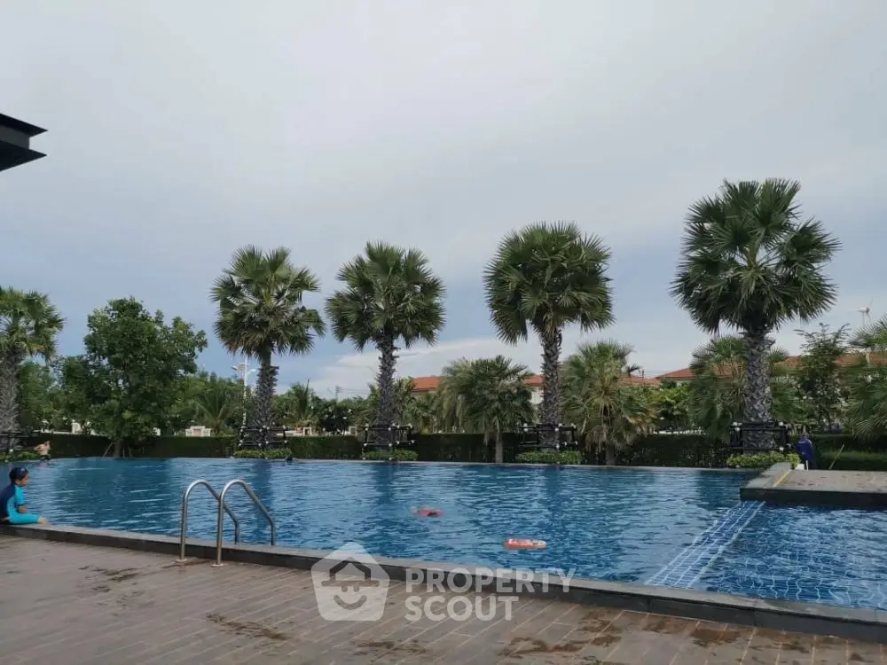 Luxurious outdoor pool with palm trees and serene surroundings, perfect for relaxation and leisure.