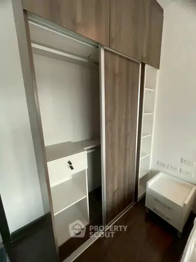 Modern built-in wardrobe with sliding doors and adjacent nightstand in a stylish bedroom.