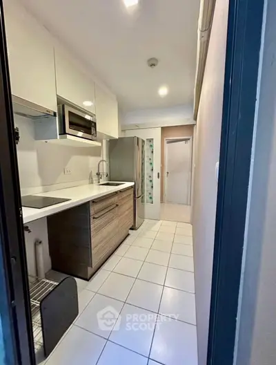 Modern compact kitchen with sleek appliances and white cabinetry