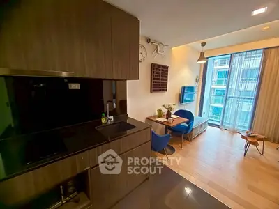 Modern open-layout living room with sleek kitchen and balcony view