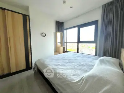 Spacious bedroom with large window offering stunning city views and modern furnishings.
