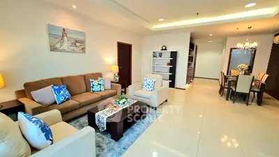 Spacious living and dining area with modern decor and elegant lighting.