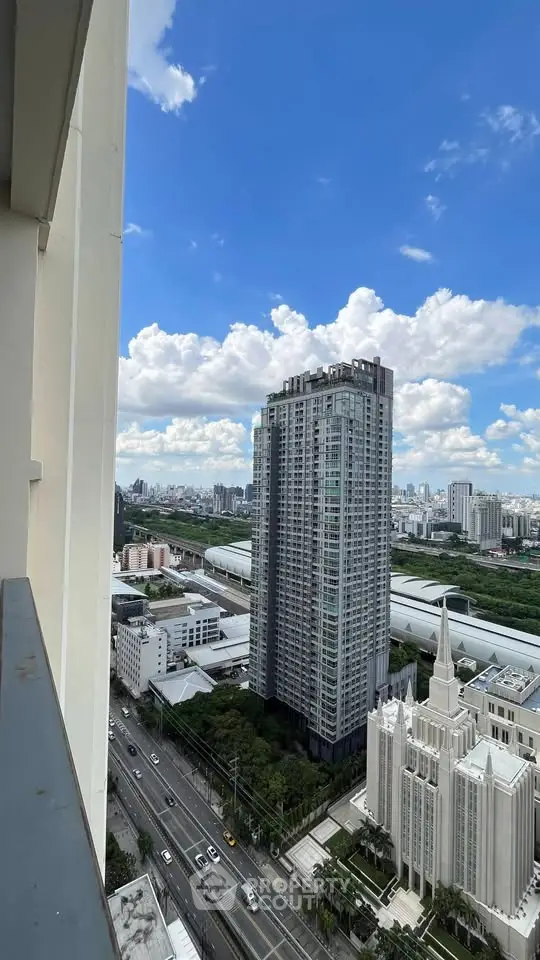 Stunning cityscape view from high-rise balcony overlooking modern skyscrapers and urban skyline.