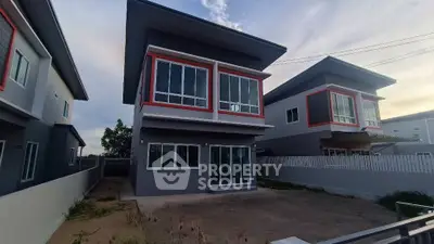 Modern two-story house with large windows and spacious driveway