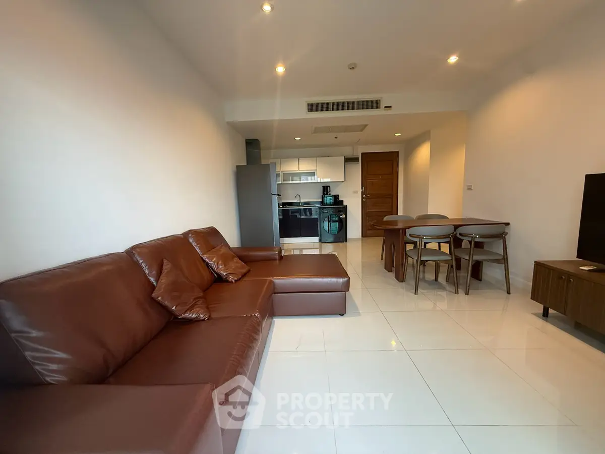 Spacious modern living room with open kitchen and stylish brown leather sofa