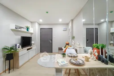 Modern living room with stylish decor and open layout, featuring a cozy dining area and entertainment center.