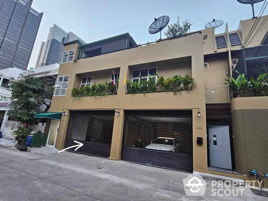 Modern urban townhouse with dual garage doors and lush greenery enhancing the facade, nestled in a vibrant neighborhood.