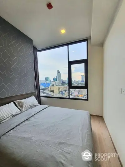 Modern bedroom with city view, large window, and stylish decor