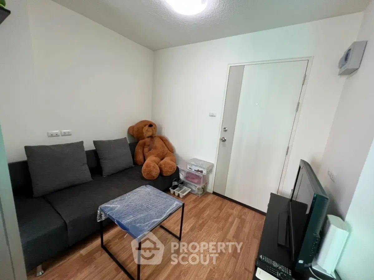 Cozy living room with modern sofa and wooden flooring, perfect for relaxation.