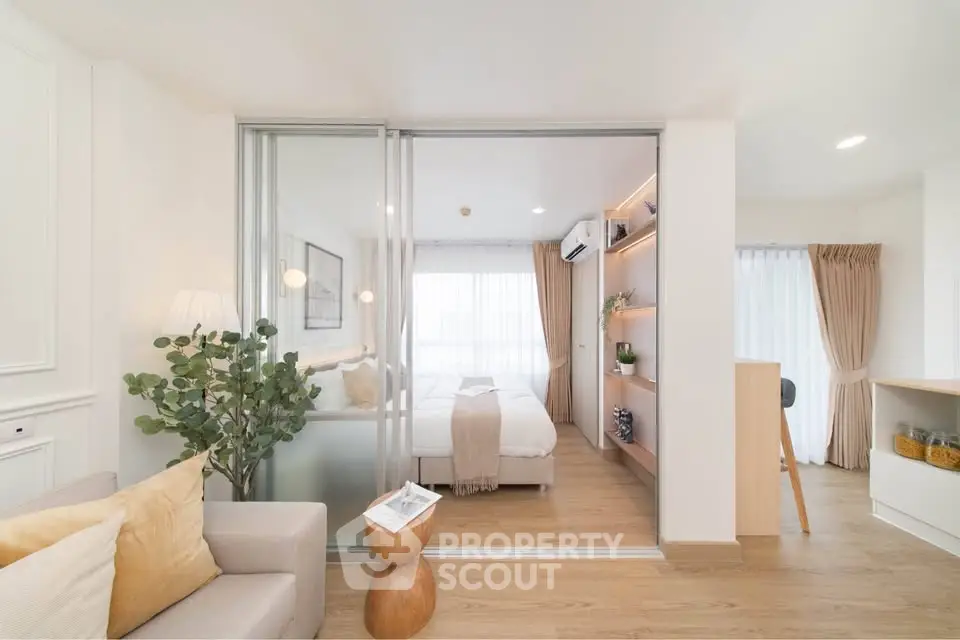 Modern open-plan living room with cozy bedroom, stylish decor, and natural light.