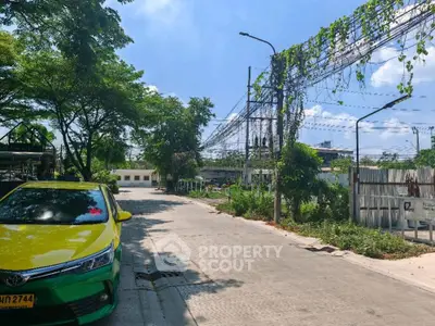 Charming suburban street view with lush greenery and clear blue sky, ideal for peaceful living.