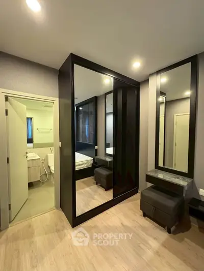 Modern bedroom with ensuite bathroom and stylish mirrored wardrobe