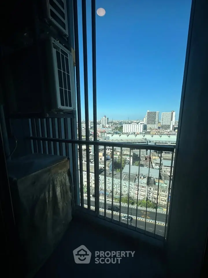 Stunning cityscape view from a high-rise balcony with clear blue sky.