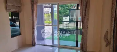 Spacious living room with large sliding glass doors opening to a lush garden view.