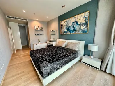 Luxurious bedroom with modern decor and elegant artwork, featuring a comfortable bed and stylish furnishings.