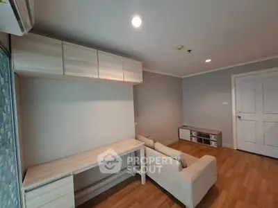 Modern living room with wooden flooring and minimalist furniture design.