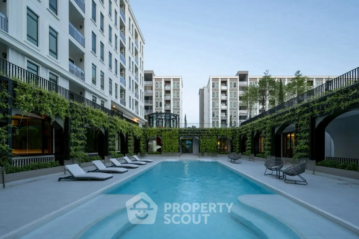 Luxurious apartment complex with modern pool and lush greenery, perfect for urban living.