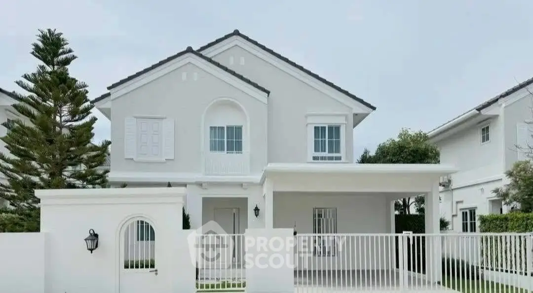 Charming two-story white house with elegant design and spacious front yard.
