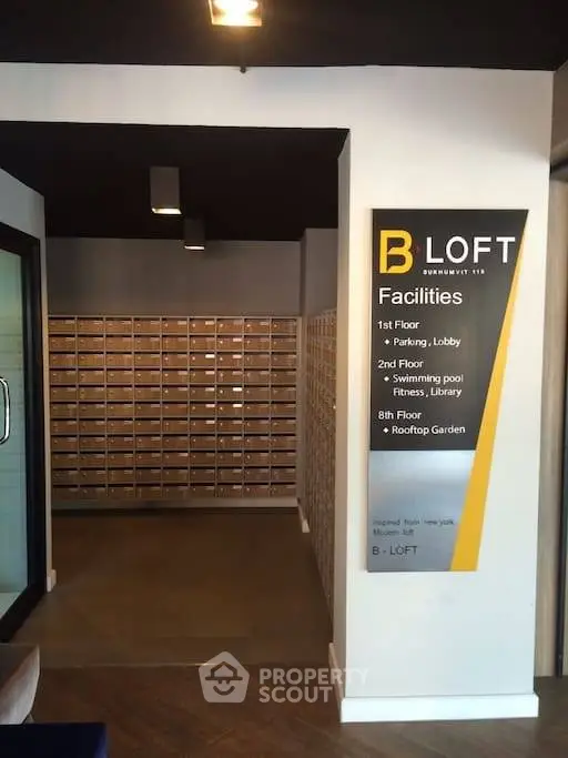 Modern apartment building lobby with mailboxes and facility sign at B Loft.