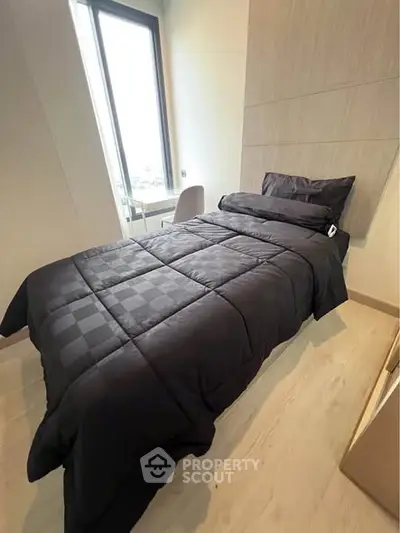 Modern bedroom with sleek black bedding and large window view