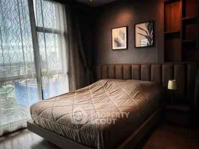 Luxurious bedroom with modern decor and large window offering stunning city views.