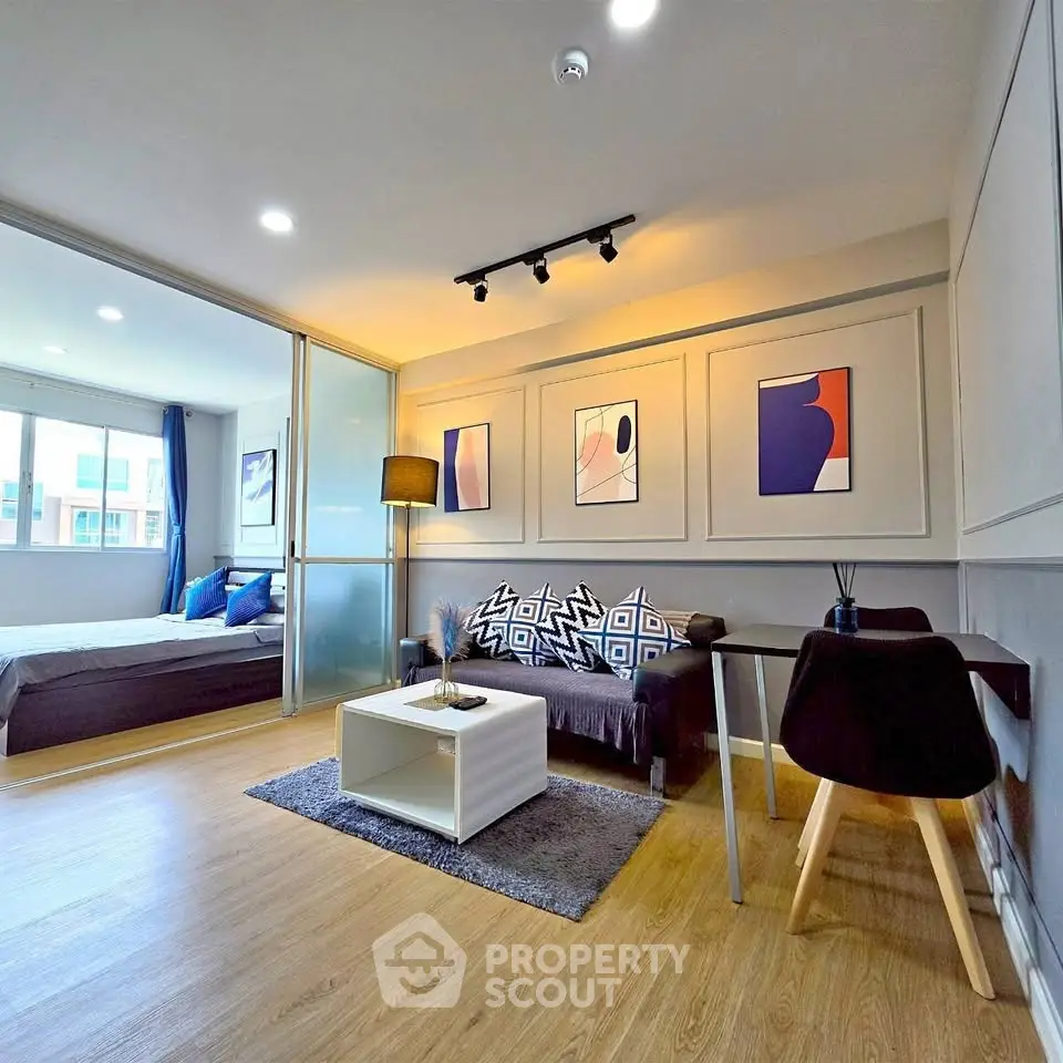 Modern open-plan living room with stylish decor and cozy bedroom view