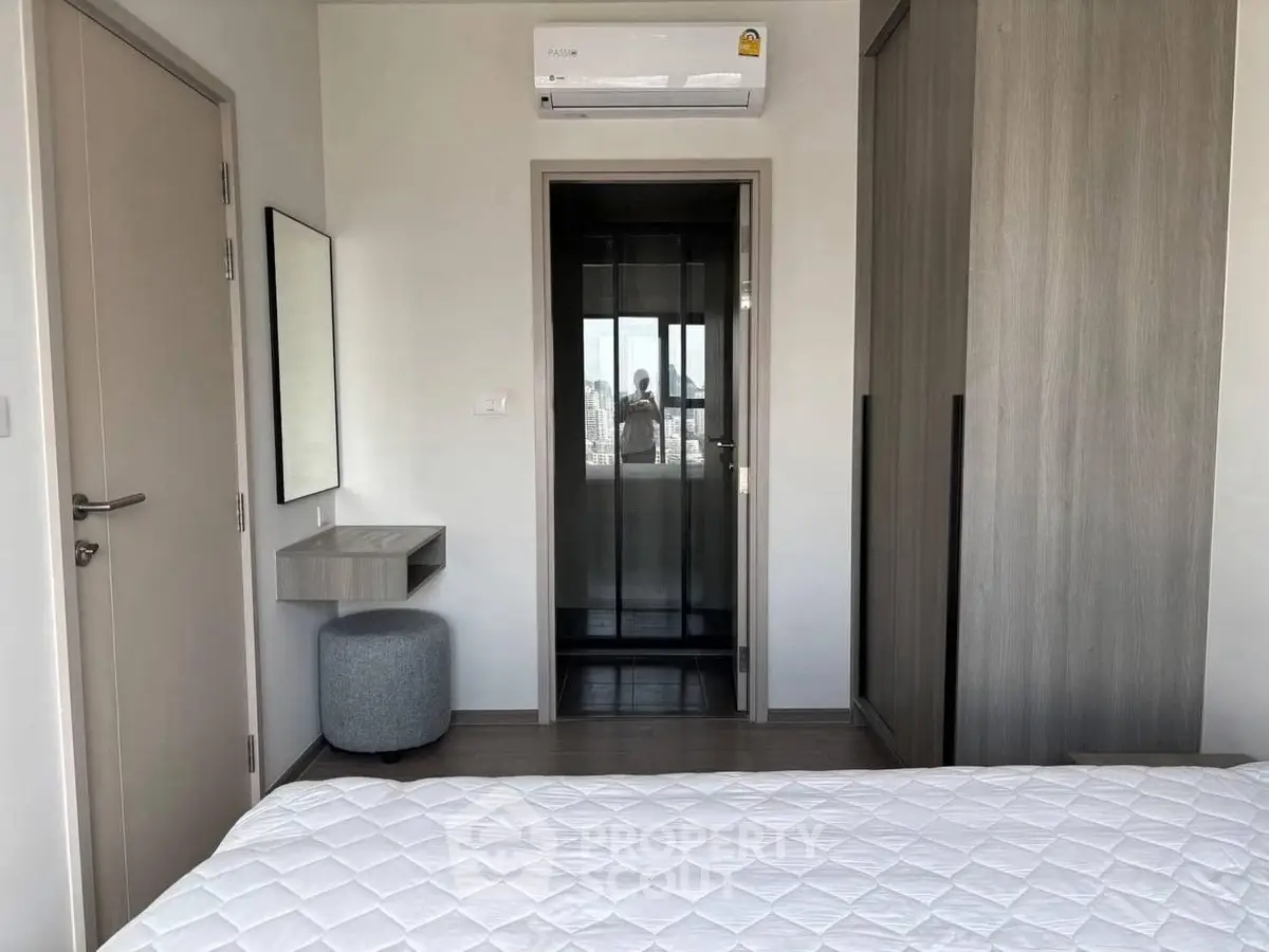 Modern bedroom with air conditioning and wardrobe, featuring a minimalist design.