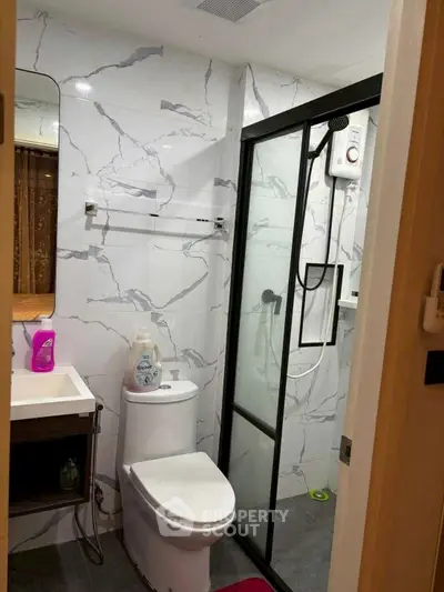 Modern bathroom with marble tiles and glass shower enclosure