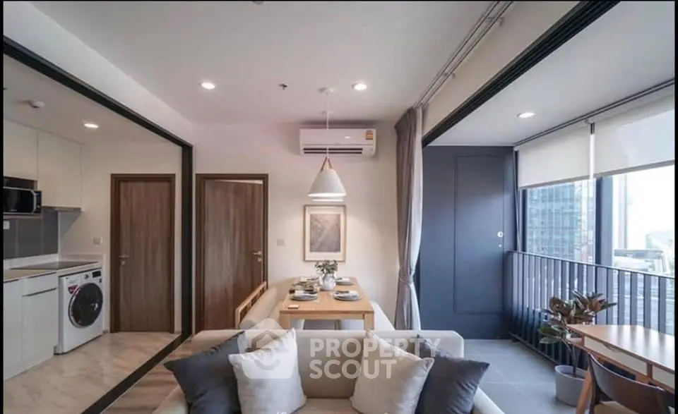 Modern living room with open kitchen and balcony view in a stylish apartment