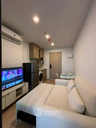 Modern compact living room with integrated kitchen and cozy sofa