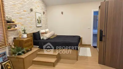 Cozy bedroom with elevated bed and stylish brick accent wall