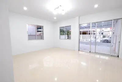 Spacious empty living room with large windows and sliding glass doors