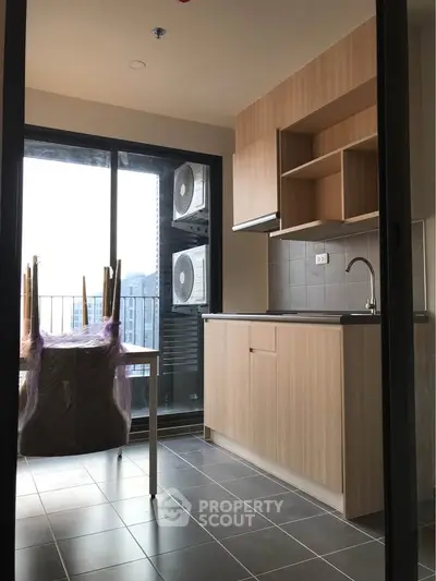 Modern kitchen with sleek cabinetry and balcony view, perfect for urban living.