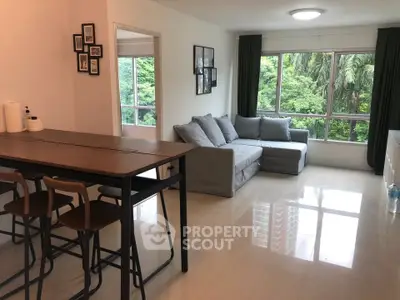 Spacious living room with modern decor and lush green view