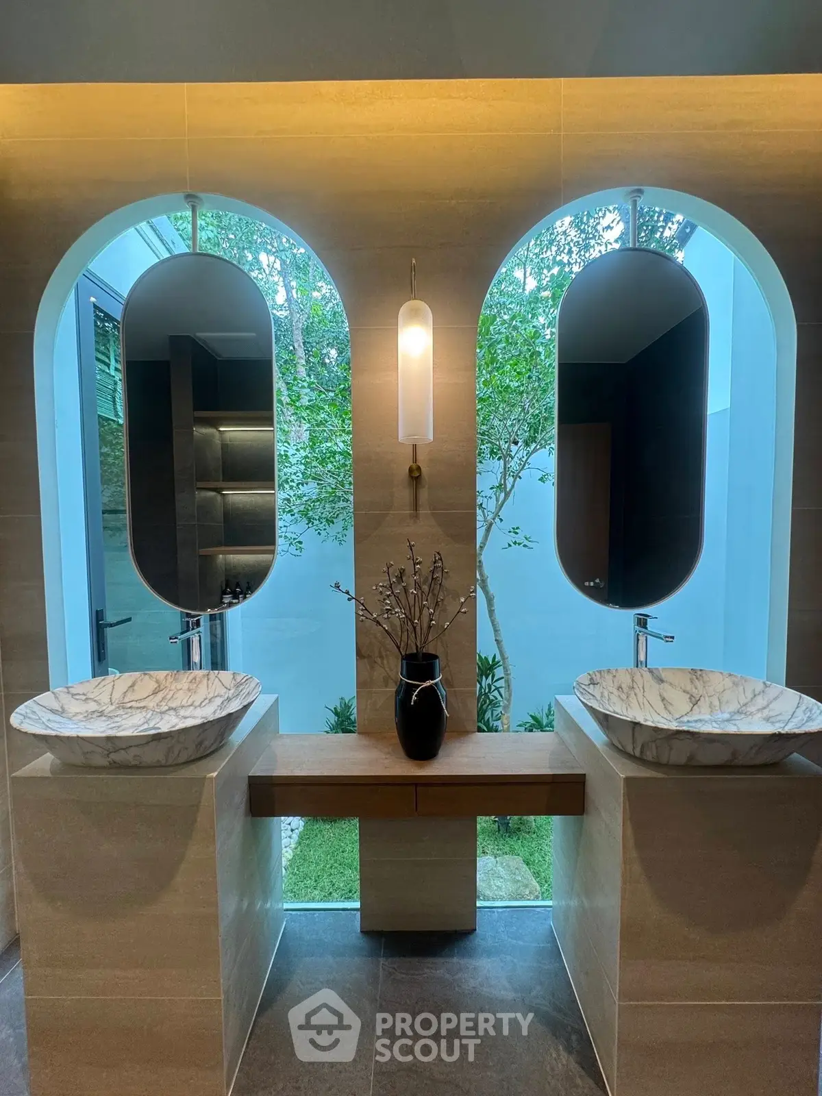 Luxurious bathroom with dual marble sinks and elegant mirrors, offering a serene garden view.