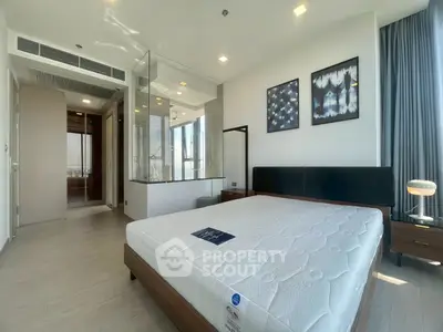 Modern bedroom with glass-walled ensuite bathroom and stylish decor