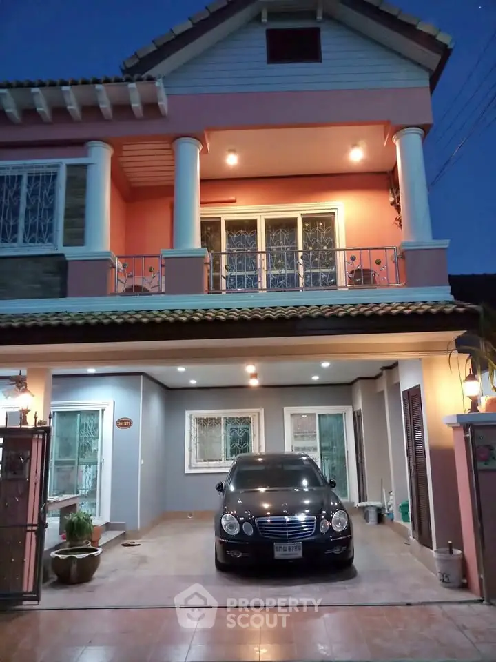 Charming two-story house with elegant facade and spacious driveway at dusk.