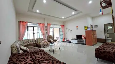 Spacious living room with modern decor and ample natural light, perfect for family gatherings.