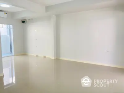 Spacious and well-lit empty room with glossy tiled flooring and ample wall sockets, perfect for a customizable living space.